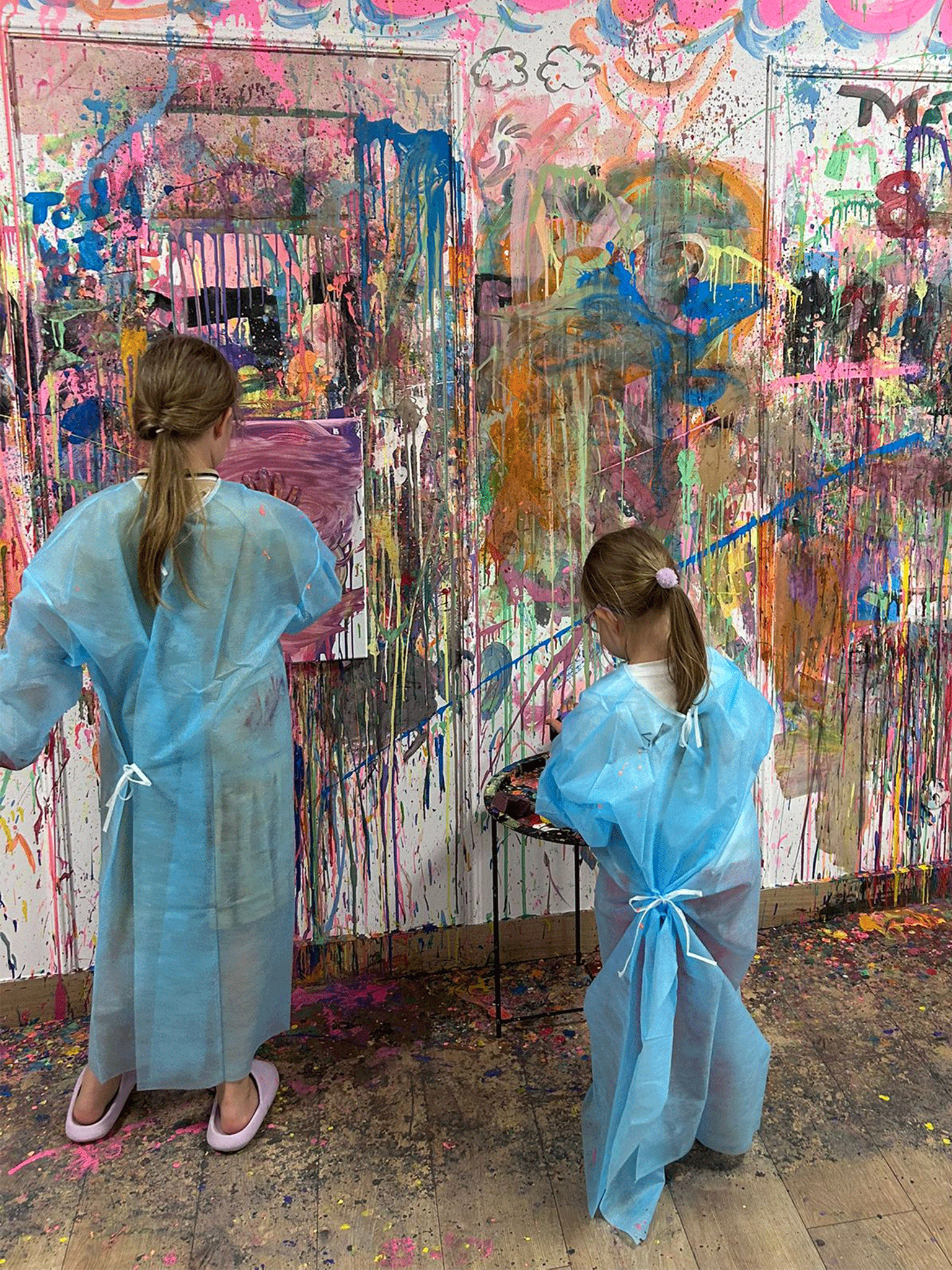 Dzieci malują obraz poprzez chlapanie farbami.