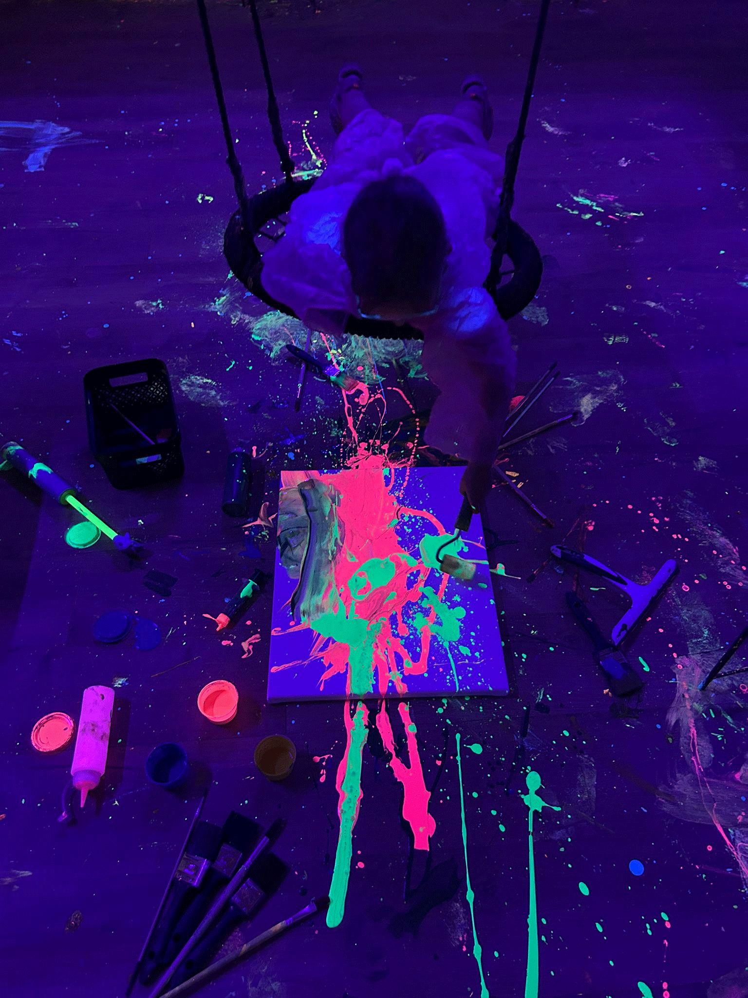 Dziecko maluje na huśtawce farbami FLUO.