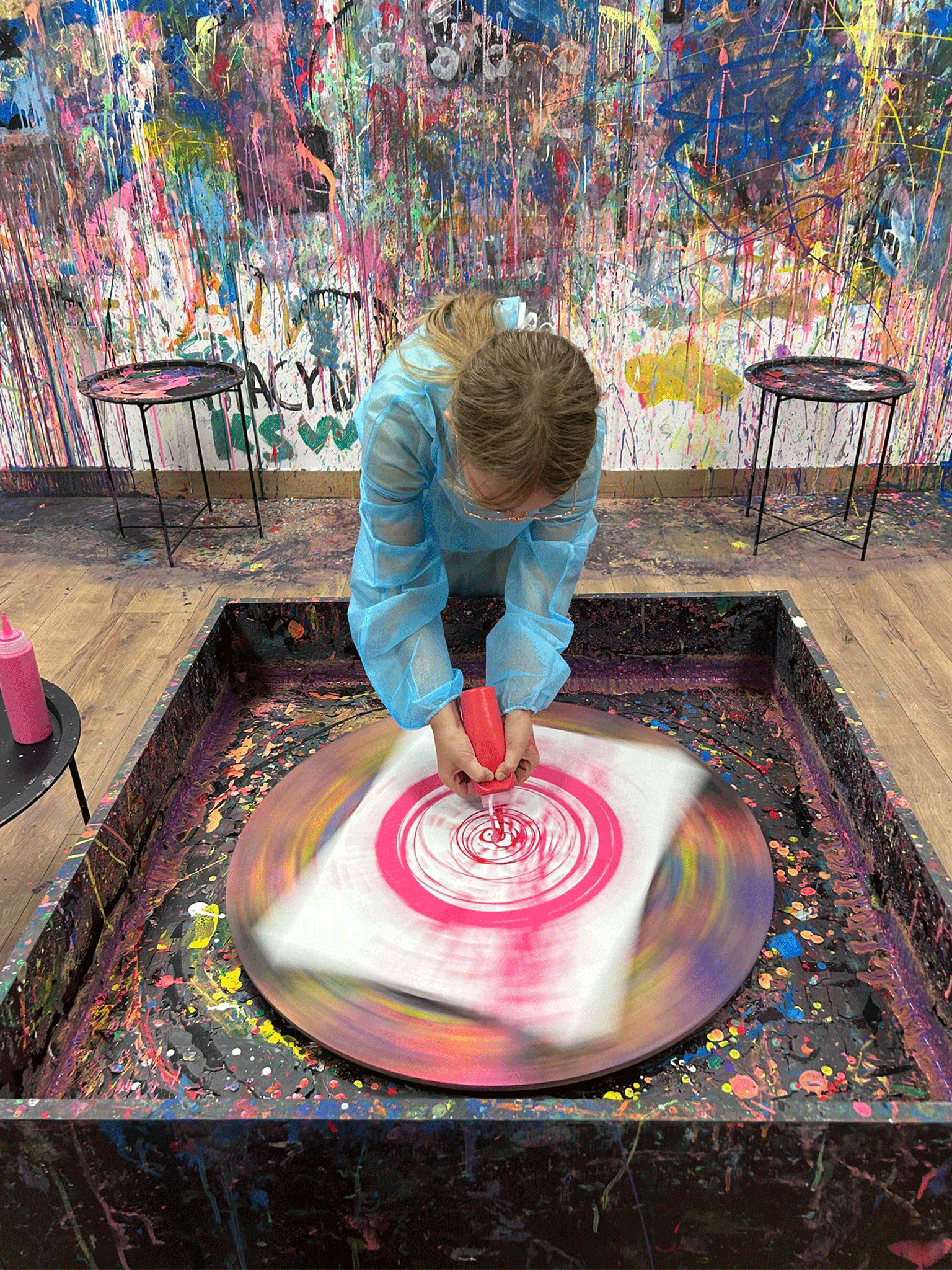 Dziewczynka maluje farbami na kręcącym się kole.